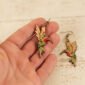 a hand holding leather hummingbird dangle earrings to show scale