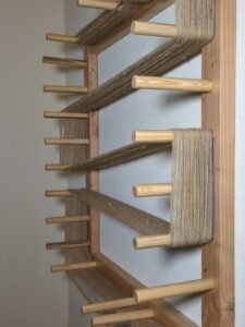 a warping board on a wall with yarn wound around it for warping a loom 