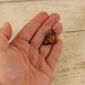 small leather monarch butterfly dangle earrings held by a hand to show scale