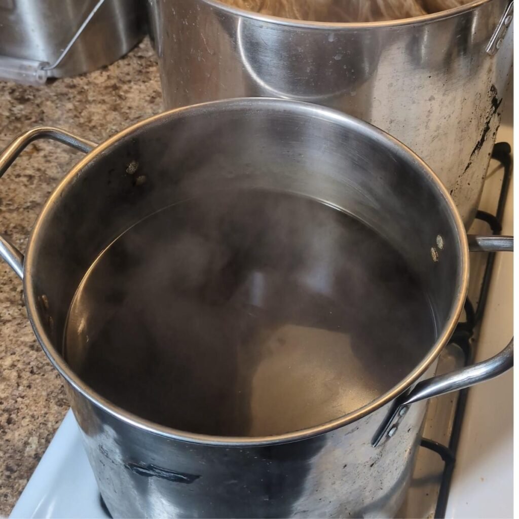 a dye pot with a dark liquid coffee ready to dye yarn
