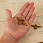 large leather bee dangle held by a hand to show scale