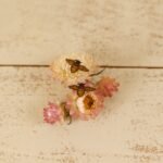 tiny leather bee stud earrings on a flower